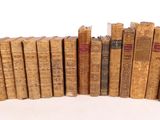 several old books stacked on top of each other on a white surface