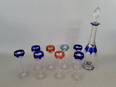 sept verres à vin et une carafe sur la table