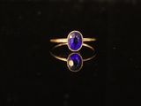 gros plan d'une bague en or avec une pierre bleue
