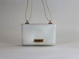 sac à main blanc avec des finitions dorées et une bandoulière en chaîne