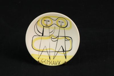 une assiette sur laquelle est représenté un dessin de deux personnes assises sur un canapé