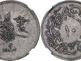a silver coin with an image of a bird on it