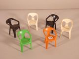 Plusieurs chaises en plastique sont disposées en cercle sur une surface blanche.