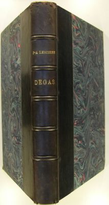 an old book with a blue cover sitting on top of a white table
