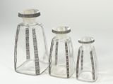 three clear glass bottles with silver trims and a silver lid