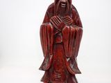 une vieille statue en bois représentant un homme barbu coiffé d'un chapeau
