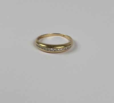 gros plan d'une bague en or avec des diamants sur une surface blanche