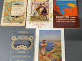 Plusieurs livres sont alignés sur une table devant un fond gris.