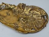 gold plate with a dog and flowers on it on a white surface