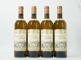 quatre bouteilles de vin sont alignées sur une surface blanche