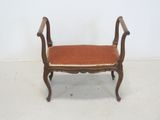 an old wooden bench with an orange upholstered seat