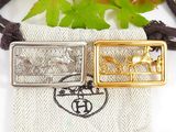 two gold and silver pendants sitting on top of a cloth bag