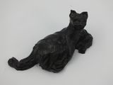 statue of a black cat laying down on a white surface
