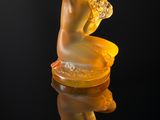 a glass figurine sitting on top of a black surface