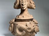 une image représentant un vase en argile surmonté d'un visage