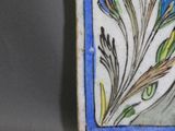 a picture of a decorative tile with a flower on it