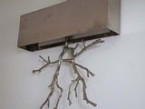 a wooden shelf with branches on it on the wall