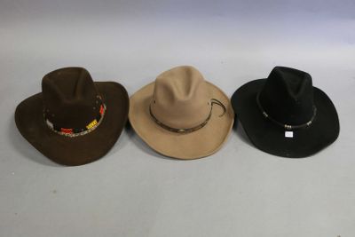 three hats are lined up on a white surface