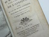 an old book that is open on a white table