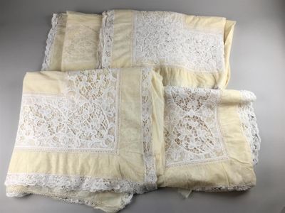 quatre morceaux de dentelle blanche posés sur une table, sur fond blanc
