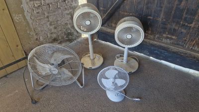 three fans sitting on the floor next to each other