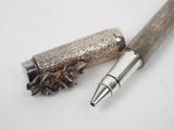 a pen that is laying on top of a piece of wood