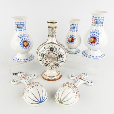 five vases and a bottle of liquor sitting on a table