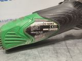 a close up of a green and black corded drill