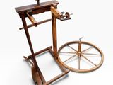an old spinning machine with a wooden wheel on a white surface