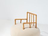 une image représentant une chaise posée sur un coussin, sur une surface blanche