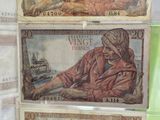 three different types of currency are on display in a glass case