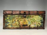 une vieille malle décorée d'une peinture, posée sur une table