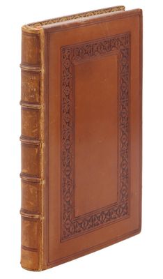 un vieux livre à la couverture en cuir marron posé sur une surface blanche