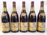 six bottles of wine are lined up on a table