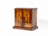 une petite armoire en bois à deux portes et deux tiroirs