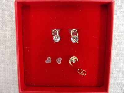 deux paires de boucles d'oreilles dans une boîte rouge posée sur une table