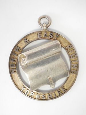 une image représentant une médaille d'argent sur laquelle figure un parchemin