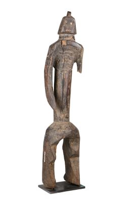 une vieille statue en bois représentant un homme coiffé d'un casque