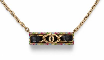 a necklace with a gold chain and a black and gold pendant