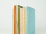 three books are stacked on top of each other on a white surface