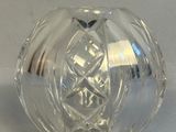 un objet en verre transparent posé sur une surface blanche