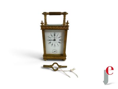 une petite horloge avec une clé posée devant