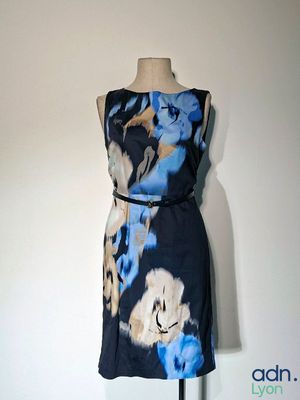 une robe posée sur un mannequin, ornée d'un imprimé floral bleu et blanc