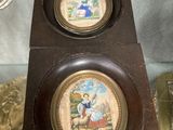une horloge sur laquelle figurent deux images, dans une vitrine en verre