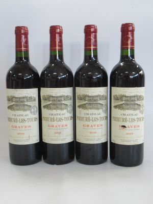 four bottles of wine are lined up on a white surface