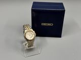 a close up of a watch on a table near a box