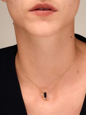 a woman wearing a black shirt and a gold necklace