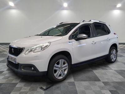 la voiture blanche est garée sur un sol en damier dans le garage