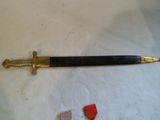 une épée noire et or sur un tissu blanc