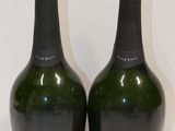 deux bouteilles de champagne posées sur une table blanche
